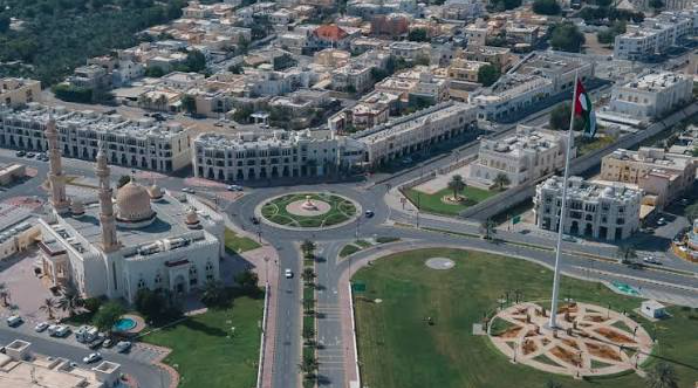 Aerial view of Al Hisn area in Abu Dhabi with mosque and flag monument, covered by our car towing service